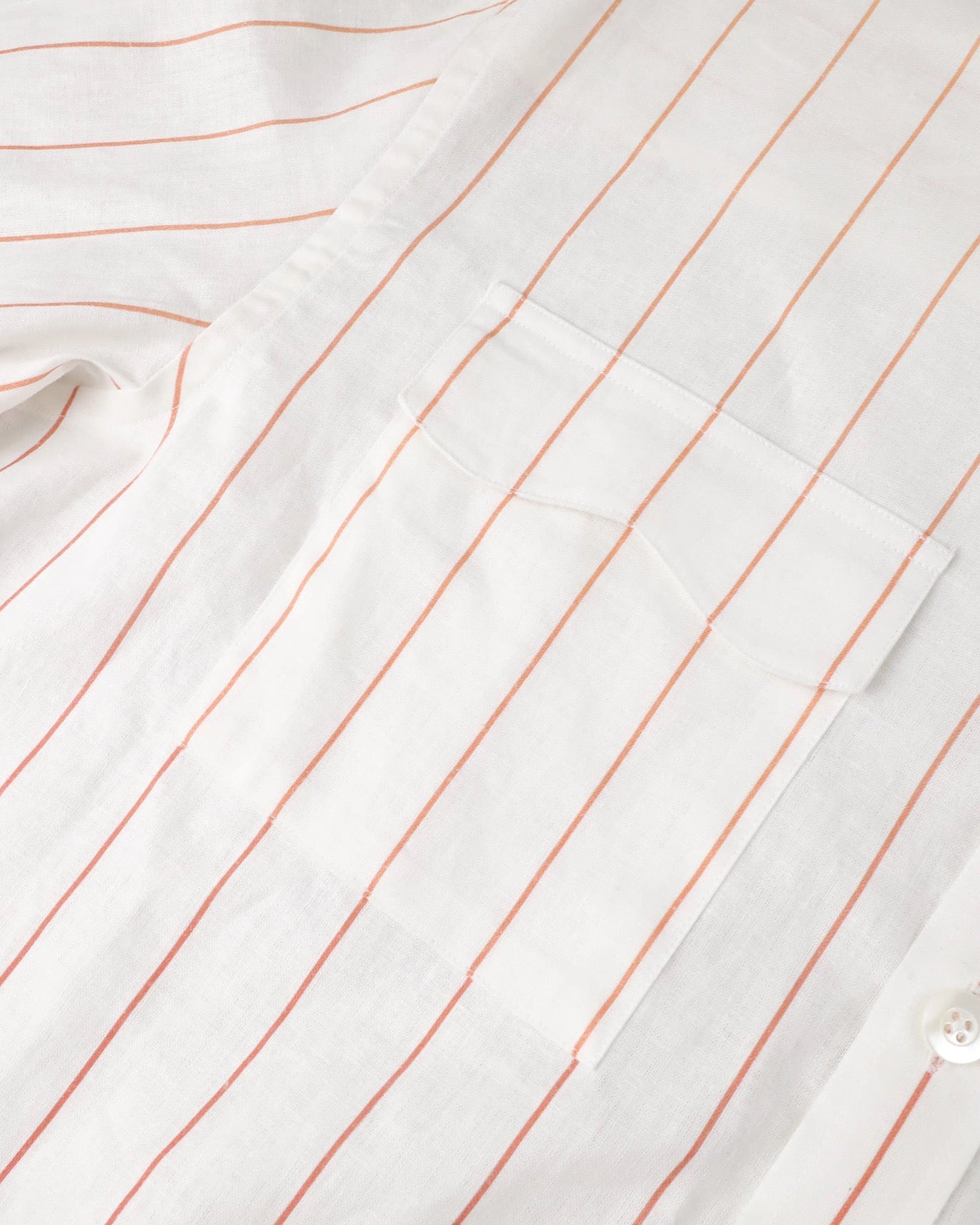 Close-up of a white shirt with red vertical stripes and buttons.